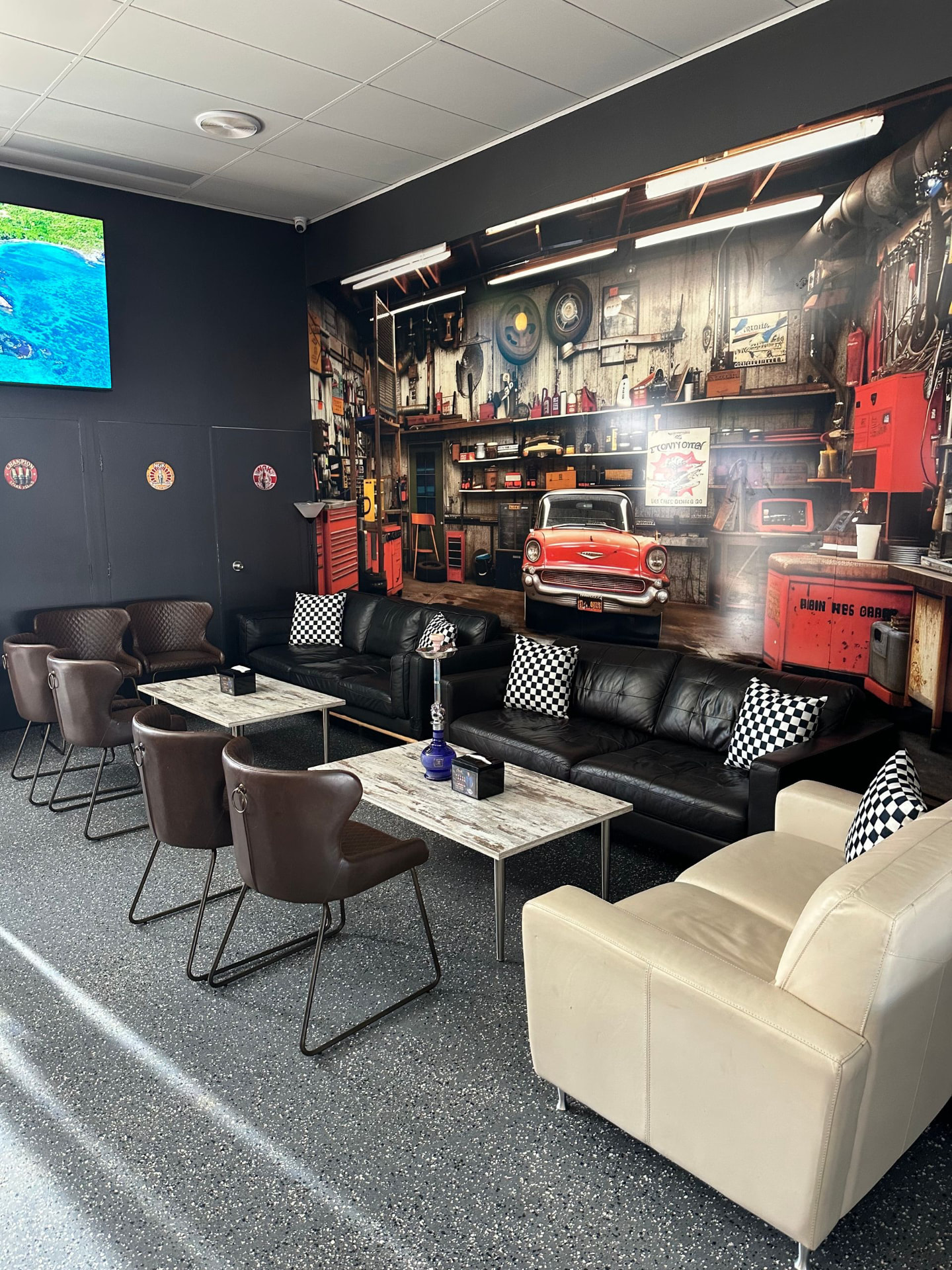 Inside The Workshop Lounge: leather lounges in front of a vintage garage mural